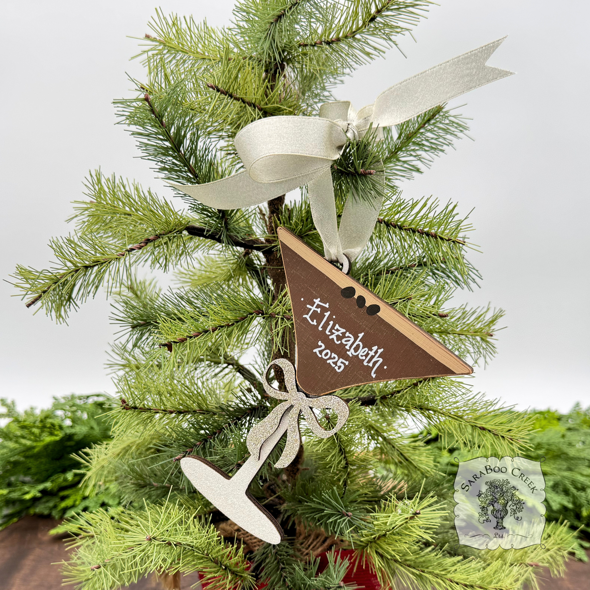 Espresso Martini shaped wood Christmas ornament hung with cream satin ribbon with white handwritten name